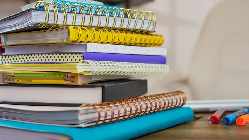 Una pila de cuadernos de espiral de colores.